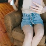 Criador de conteúdo sensual trabalhando com smartphone em ambiente moderno