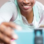 Criadora de conteúdo adulto usando smartphone com expressão confiante