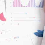 Pessoa usando laptop com gráficos e símbolos digitais relacionados a marketing adulto