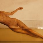 mulher posando de forma sensual com iluminação suave e ambiente íntimo