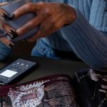 Pessoa usando smartphone para acessar uma plataforma de conteúdo digital adulto